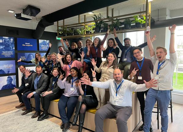 A group of 20 people form all over the world excited and smiling