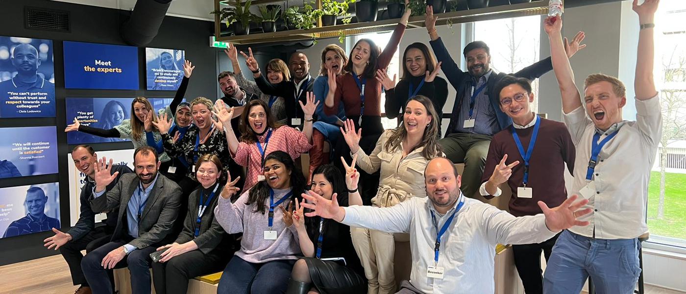 A group of 20 people form all over the world excited and smiling